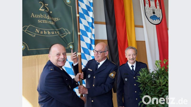 Der Leitende Polizeidirektor Josef Strobl (Mitte) gab die Fahne des 25. Ausbildungsseminars und damit auch symbolisch die Leitung der Nabburger Bereitschaftspolizei-Außenstelle weiter von Polizeioberrat Gernot Schötz (rechts) an Polizeirat Helmar Termer (links).	Bild: Götz