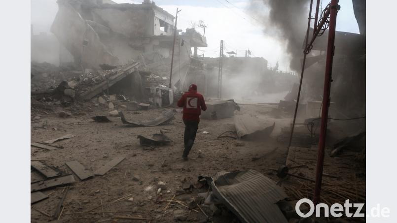 Ein Mitarbeiter der Organisation Syrischer Roter Halbmond geht durch ein Viertel der Stadt im syrischen Rebellengebiet Ost-Ghuta nahe Damaskus, das von Angriffen der syrischen Luftwaffe getroffen wurde. Foto: Samer Bouidani/dpa dpa