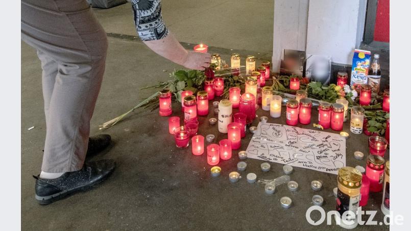 Eine Frau stellt eine Kerze am Tatort ab. Der bei einer Schlägerei in der Passage getötete Jugendliche war an seinem Blut erstickt. 	Bild: Armin Weigel/dpa