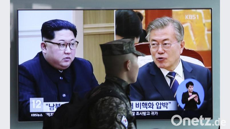 Ein südkoreanischer Soldat geht an einem Bildschirm vorbei, der Bilder des nordkoreanischen Machthabers Kim Jong Un (links) und Moon Jae In, dem Präsident von Südkorea, zeigt. 	Bild: Ahn Young-Joon/dpa