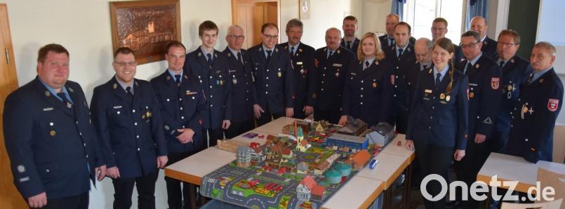 Kreisbrandinspektor Lorenz Müller (Siebter von links) und Kreisbrandrat Andreas Wührl (Achter von links) besprechen mit den Teilnehmern des Lehrgangs Einsatztaktik bei Planspielen unter anderem die Fahrzeugaufstellung und das taktische Vorgehen bei größeren Bränden. 	Bilder: mde (2)