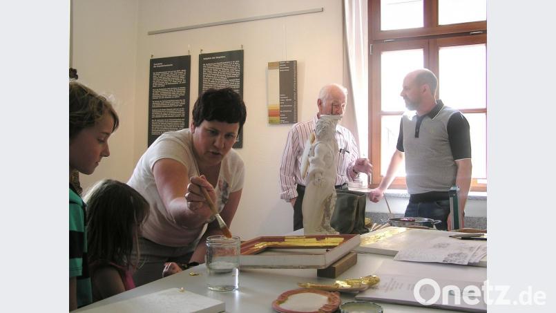 Klein und Groß interessieren sich am Sonntag im Stadtmuseum für die theoretischen und praktischen Ausführungen von Kirchenmalermeisterin Monika Müllner und ihrem Bruder, Vergoldermeister Tobias Müllner, zum Thema "Faszination Gold - Vergolden und restaurieren".  	Bild: tu