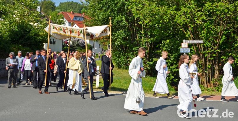 Mitglieder der Kirchenverwaltung und des Pfarrgemeinderats tragen bei der Flurprozession am Sonntag den Baldachin, unter dem Pfarrer Helmut Süß die Monstranz mit dem eucharistischen Brot mitführt.  	Bild: ü
