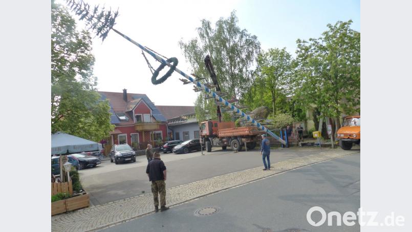 Mit Hilfe eines Kranwagens ist der Zunftbaum schnell aufgestell. Vorsitzender Michl Schwabl (vorne, mit Hut) beoachtet die Arbeiten.  	Bild: sl