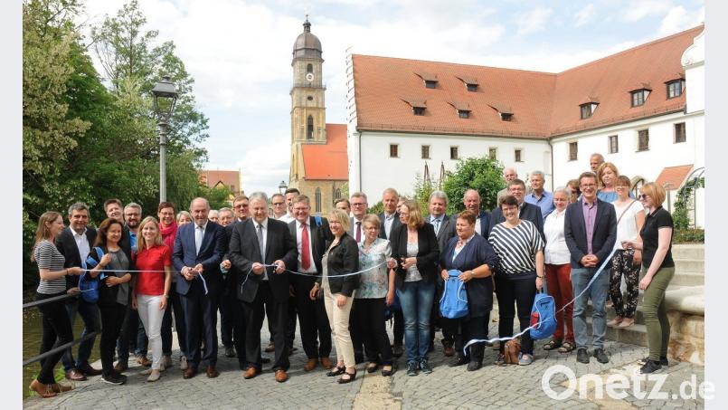 Die Landräte Willbald Gailler (Neumarkt, Fünfter von links) und Richard Reisiger (Amberg, rechts daneben) sowie Cornelia Bubb, die Managerin des Kooperationsprojekts, zerschneiden das Band zur Neueröffnung des Fünf-Flüsse-Radwegs.  	Bild: Stephan Huber