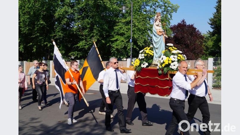 Das Tragen der Muttergottesstatue im Kirchenzug hat am Patroziniumstag der Pfarrei "Maria Königin" Tradition. Das Fest wirde bereits zum 55. Mal begangen. Die Trage schultern wieder vier Kolpingmitglieder. Bild: du
