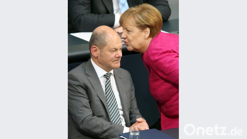 Finanzminister Olaf Scholz (SPD) und Bundeskanzlerin Angela Merkel (CDU) während der Plenarsitzung des Bundestages im Gespräch. Bild: Wolfgang Kumm/dpa
