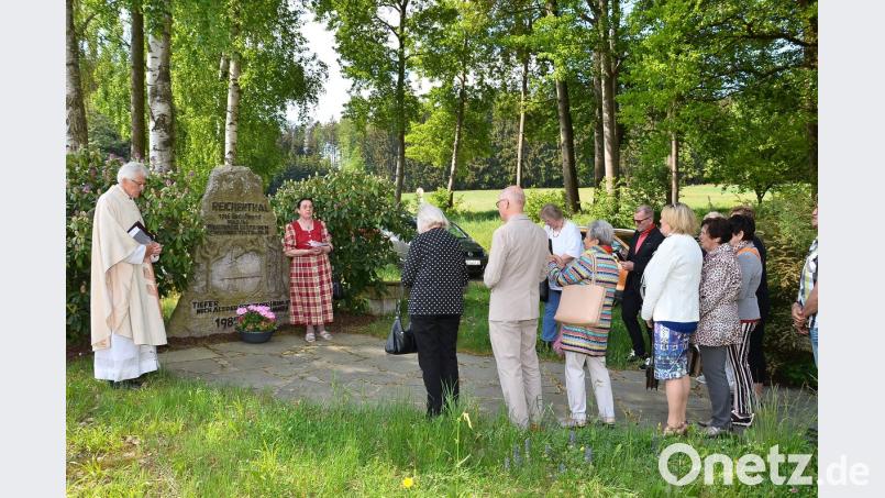 Pfarrer Georg Hartl und Amalie Grubwinkler (von links) erinnern am großen Gedenkstein an die Opfer der beiden Weltkriege. Bild: fjo