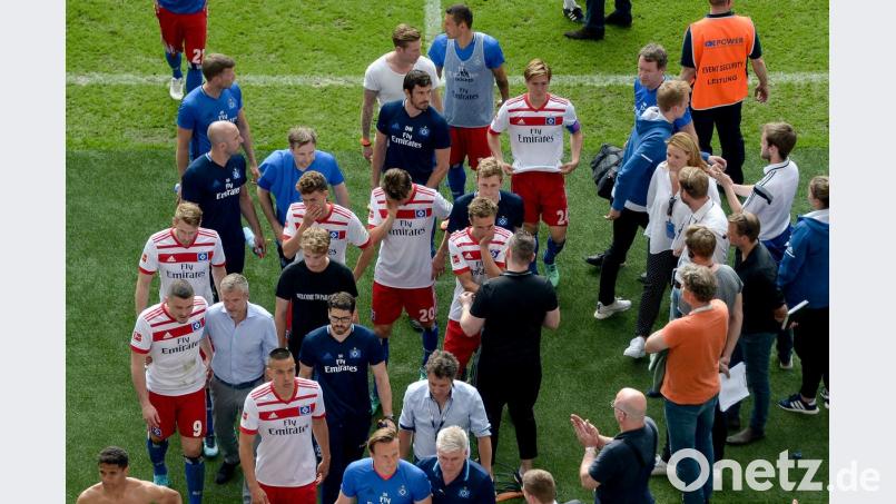 Enttäuscht schleichen die Spieler des HSV vom Platz. Nach 55 Jahren ist das Gründungsmitglied aus der Bundesliga abgestiegen.  	Bild: Axel Heimken/dpa