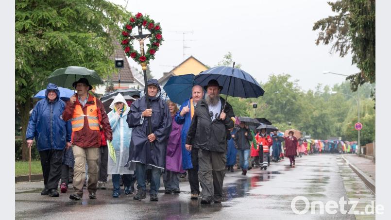Bei starkem Regen zogen am Donnerstag Tausende Pilger Richtung Altötting. Die größte deutsche Fußwallfahrt führt von Regensburg aus in den 111 Kilometer entfernten Marienwallfahrtsort. Unterwegs schließen sich immer wieder Pilger dem kilometerlangen Zug an. Bild: Peter Kneffel/dpa