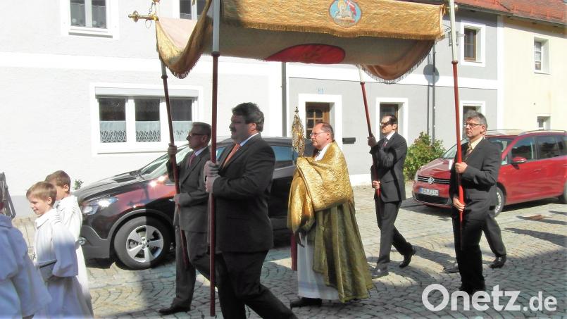 Angeführt von den Ministranten und der Blaskapelle Waldeck ziehen die Vereine, Pfarrer Heribert Stretz mit der Monstranz und die Gäubigen bei der Prozession durch den Oberen und Unteren Markt, um ihren Kirchenpatron zu ehren hl