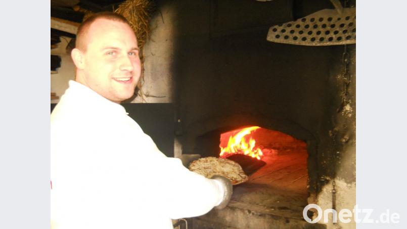 Florian Pappenberger backt beim Backofenfest herzhaften Zwiebelkuchen, Museumsbroteund Speck-Käsestangen im alten Holzbackofen. exb