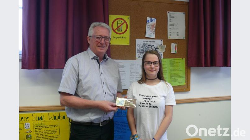 Klassensprecherin Laura Seelk überreicht im Namen der Klasse an Franz Malzer eine Schokoladentafel mit dem Schriftzug "Danke".
Bild: exb