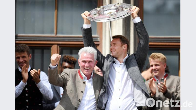 Trainer Jupp Heynckes (links) bedankt sich bei den Fans. während Torwart Manuel Neuer die Meisterschale hochhält: Auch wenn die Niederlage im DFB-Pokal wehtat, ließen sich die Bayern-Spieler am Marienplatz von ihren Fans feiern.  	Bild: Tobias Hase/dpa