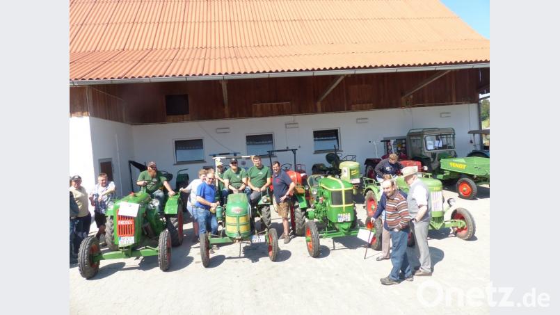 Zweiter Bürgermeister Karl Liegl (links vom Bulldog) und Feuerwehr-Vorsitzender Peter Schwabl (rechts vom Bulldog) begrüßen beim Oldtimertreffen in Lerau die größte Gruppe, den Zapfwellenstammtisch &quot;Alts Glump&quot; aus Mantel.	Bild: sl