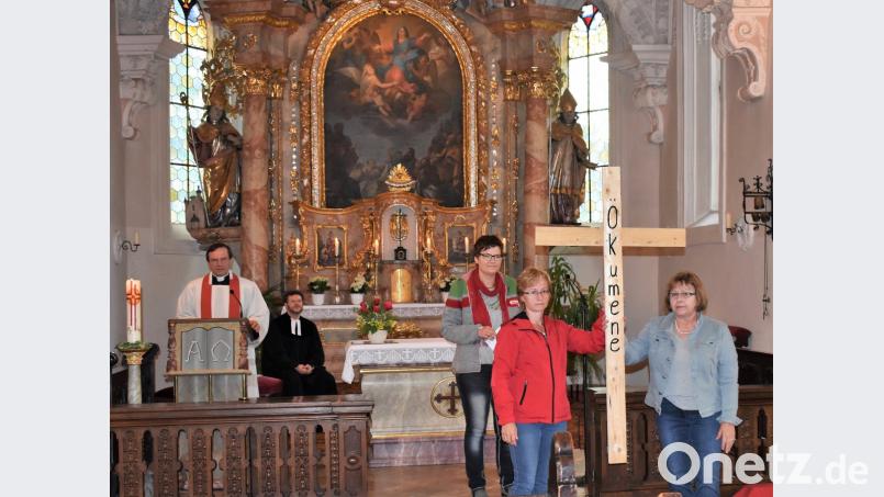 Mit zwei Holzbalken wird in dem ökumenischen Pfingstgottesdienst ein Kreuz gebildet - als Symbol, dass Katholiken und evangelische Gläubige dennoch viele Gemeinsamkeiten haben.  	Bild: rgr