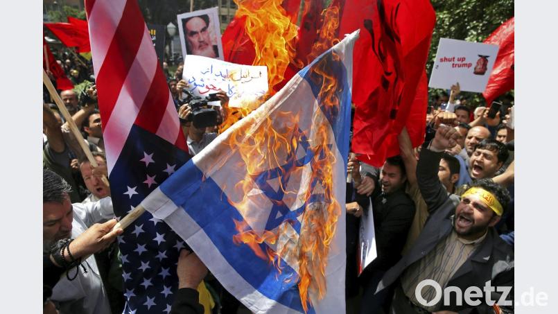 Brennpunkt Naher Osten: Iranische Demonstranten verbrennen bei einer pro-palästinensischen Versammlung israelische und US-amerikanische Flaggen.  
	Bild: Ebrahim Noroozi/AP/dpa