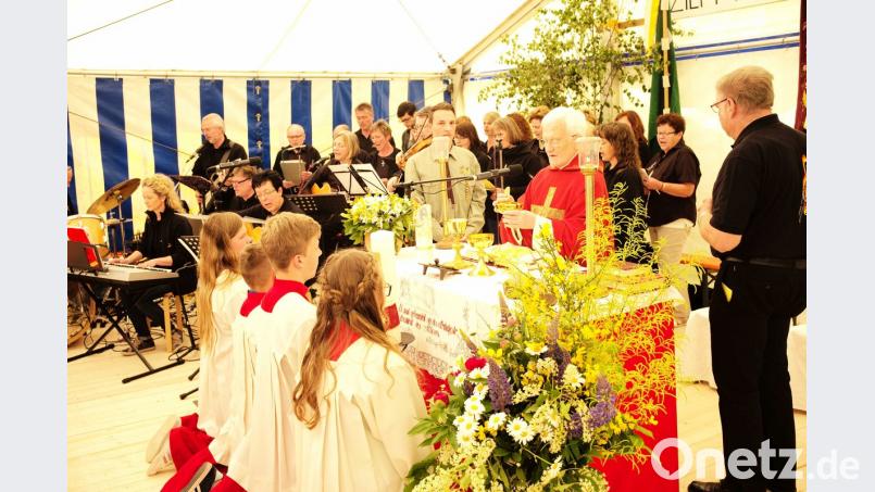 Pfarrer Andreas Schlagenhaufer zelebrierte den Festgottesdienst, im Bild mit den Ministranten, Kommunionhelfern und dem Musikkreis	Bild: Hans Fischer