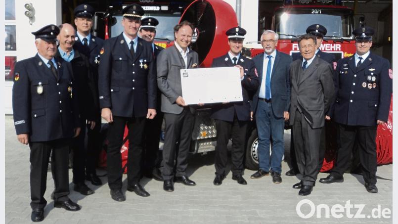 Einen Scheck in Höhe  von 25500 Euro überreichte Geschäftsführer René Guhl an die Feuerwehr-Führung. Bild: ksi