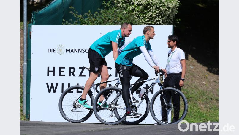 Auf einem Cube-Bike fährt Torwart Manuel Neuer (Mitte) zum Training der Deutschen Fußball Nationalmannschaft. Christian Charisius/dpa