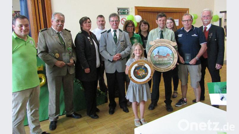 Bei der Siegerehrung des Jubiläumsschießens der Speckbachpelzer: Schützenmeister Josef Diertl (links), Gauschützenmeisterin Rebecca Kramer (Dritte von links), die beste Einzelschützin Michaela Forsmann (Sechste von links), die Gewinnerin der Bogen-Eröffnungsscheibe, Magdalena Kroher (Siebte von links), Jens Wittmann (Neunter von links) mit der Patenvereinsscheibe, und der Präsident des Oberpfälzer Schützenbunds, Franz Brunner (rechts). SCK