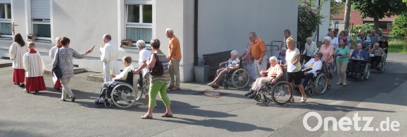 Pfarrer Josef Wittmann und die Ministranten führten die Lichterprozession um das BRK-Heim St. Ägidius an. rha