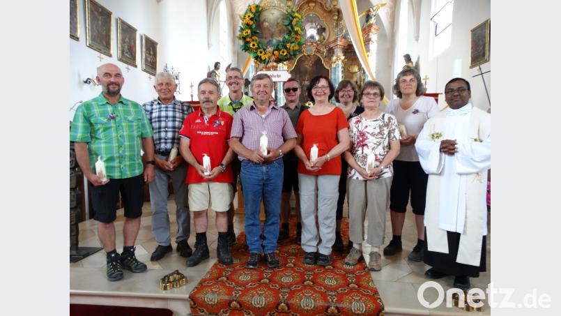 Pfarrvikar Hruday Madanu (rechts) und Wallfahrtsführer Edmund Heldmann (Vierter von links) ehren zahlreiche Wallfahrer für ihre oftmalige Teilnahme (von links): Willi Pausch, Christian Weiß, Peter Andraschko, Manfred Härtl, Resi Regler, Christine Ratzke, Marianne Merkl und Roswitha Hufsky sowie in der  Mitte hinten mit dem Wallfahrtsbild Gerald Hüttner. ct