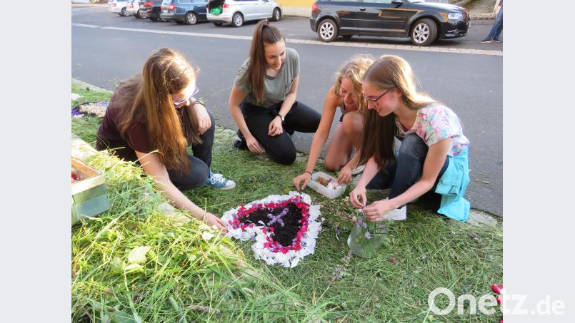 Jugendliche und Kinder beim Gestalten eines Blumenteppichs in Neualbenreuth. Ulla Britta Baumer