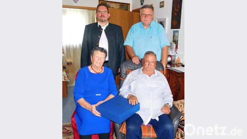 Mit einem hochwertigen Tee-Set, blau verpackt mit bayerischem Staatswappen, gratuliert Ministerpräsident Markus Söder dem Jubelpaar Lenja (83) und Gottlieb Dewald (84) zu 65 gemeinsamen Lebensjahren. Glückwünsche überbrachten persönlich Pfarrer Micha Boerschmann (stehend links) für die evangelische Kirchen- und Bürgermeister Manfred Porsch für die politische Gemeinde. hai