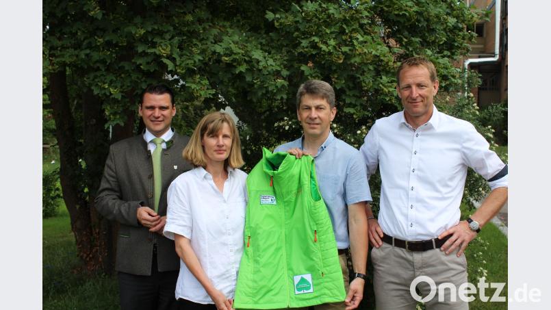 Die neue Gebietsbetreuerin Birgit Simmeth erhält von ihrem Vorgänger Markus Kurz symbolisch die markant grüne Jacke der Gebietsbetreuer. Landrat Thomas Ebeling (links) und Geschäftsführer Christian Meyer (rechts) gratulieren. Bild: Pressestelle Landratsamt Schwandorf