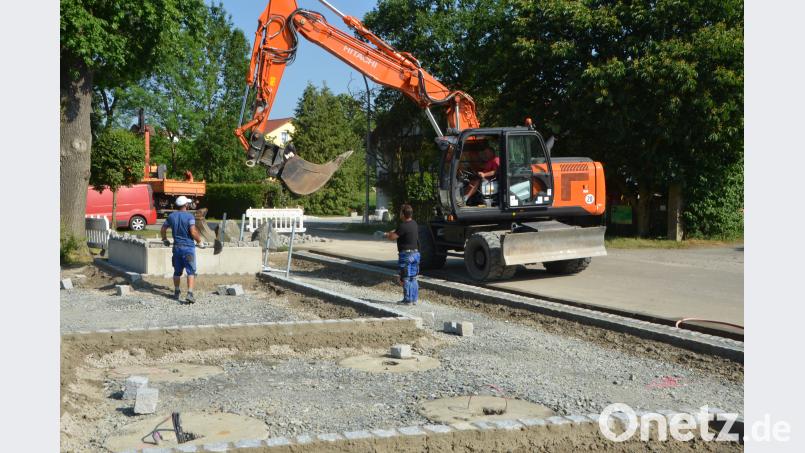 Die Umfeldgestaltung am Glockenturm Unterlind nimmt bereits Formen an. Pflasterbauer aus dem Bayerischen Wald legen die Steine aneinander. Die Stadtarbeiter unterstützen beim Herankarren der Baumaterialien. dob