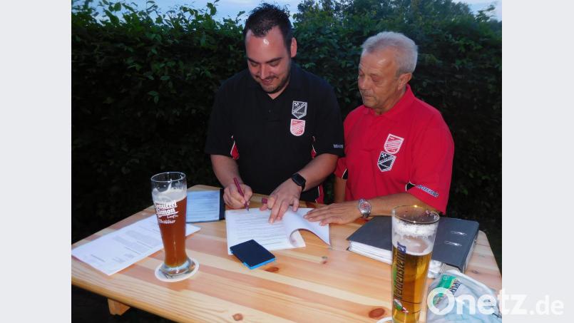 Jürgen Neubauer (links) und Roland Laier unterzeichnen die Kooperationsvereinbarung. Das  Weißbier steht  bereit, um darauf anzustoßen. exb