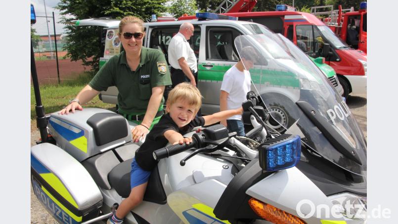 Der dreijährige Julian nimmt Platz auf einem Polizei-Motorrad. Den Lenker hat er noch nicht so gut im Griff. Dahinter schaut Brigitte Herzog auf. kro
