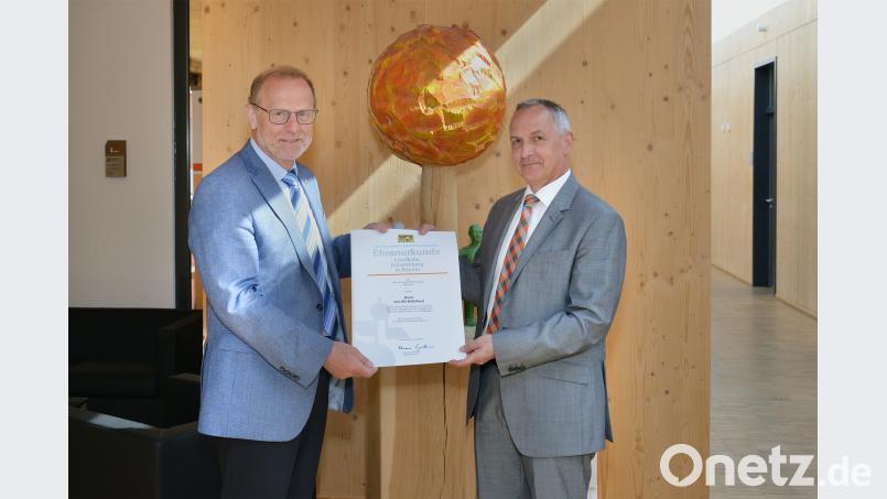 Behördenleiter Thomas Gollwitzer überreicht Willi Perzl die goldene Ehrennadel zur Würdigung seines außergewöhnlichen Engagements für den Ländlichen Raum. exb