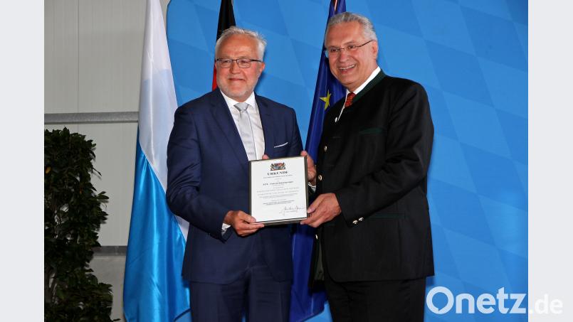 Innenminister Joachim Herrmann händigte Geschäftsführer Hans  Fleischmann (links) die Urkunde "Ehrenamtsfreundlicher Betrieb" aus. exb