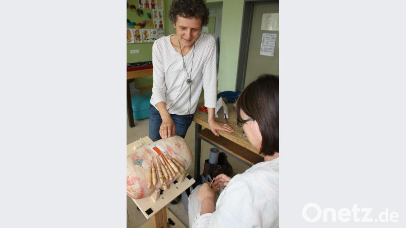 Kursleiterin Birgit Härtel (links) mit einer Kursteilnehmerin. Nach einer gezeichneten Vorlage entsteht ein Ohranhänger, ein Würfel aus Edelstahldraht. eib