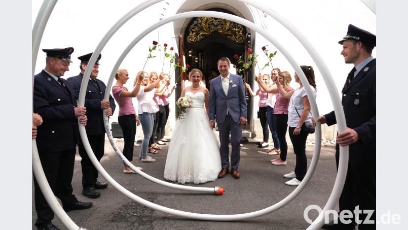 Bei der Hochzeit von Michaela Käs und Sebastian Schell stehen die Festdamen und Feuerwehrmänner der Feuerwehr Spielberg am Kirchenportal. fvo