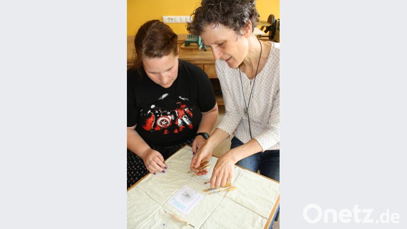 Kursleiterin Birgit Härtel (rechts) mit einer Kursteilnehmerin. Auch bei einer Brosche aus Edelstahldraht wird nach einer gezeichneten Vorlage gearbeitet. eib