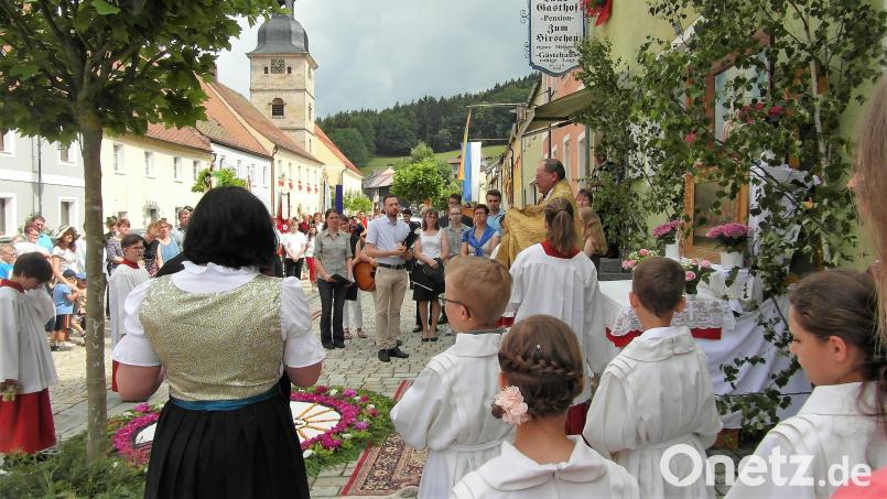 An jeden der drei Altäre segnet Pfarrer Heribert Stretz (hinten) die Gläubigen mit der Monstranz. Die jeweiligen Blumenteppiche legen Frauen aus Köglitz. hl