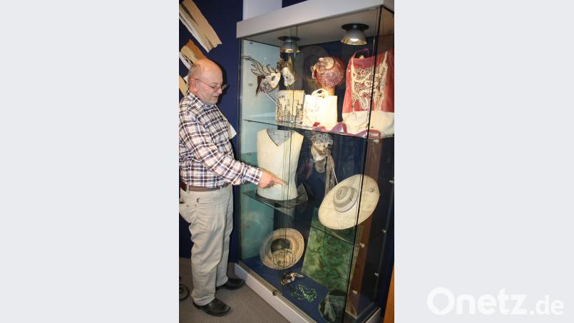 Josef Köck, Inhaber des seinem Kaufhaus angeschlossenen Klöppelshops, präsentiert auf der Klöppeletage die Ausstellung „Unkonventionelle Materialen in der tschechischen Klöppelspitze“ bis Mitte August. Er zeigt auf eine Hutkreation, in der die Künstlerin Zeitungspapier als Hutschirm eingearbeitet hat. eib