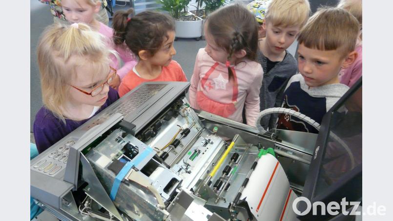 Die Mitarbeiter der Sparkasse erklären den Mädchen und Buben nicht nur wie ein Bankautomat funktioniert, sondern zeigen ihnen auch das Innenleben der Maschine. hai