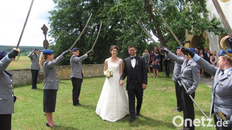Das frisch getraute Ehepaar Lea und Johannes Grill durchschreitet ein Spalier aus Säbeln. sei