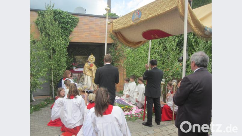 Pfarrer Dr. James spendet den Teilnehmern der Fronleichnamsprozession den eucharistischen Segen mit dem Allerheiligsten am Altar und Blumenteppich der Familie Hösl/Höfer. Andreas Schwohnke