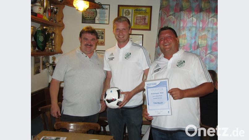 Kreisspielleiter Albert Kellner (links) gratuliert dem TSV Reuth zur Kreisklassenmeisterschaft und überreichte Hansi Stangl die Urkunde und Spielführer Jonas Zeitler einen Spielball. ang