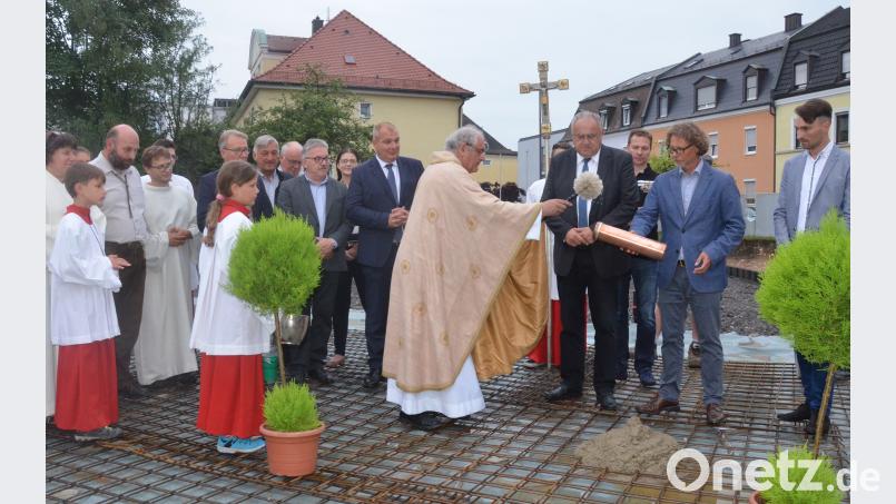 Stadtpfarrer Gerhard Pausch segnet die "Zeitkapsel", die zur Grundsteinlegung in das Fundament des neuen Pfarrheims betoniert wird. Es assistieren Pfarrvikar Andreas Reber, Bürgermeister Lothar Höher und Architekt Manfred Schwemmer. Kunz