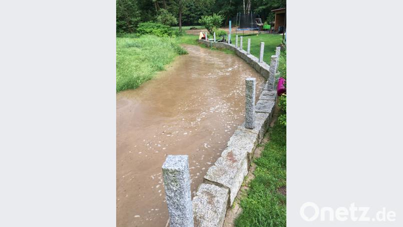 Die Regenfälle machen aus einem Rinnsal einen reißenden Bach, der fast über das Ufer tritt. hl