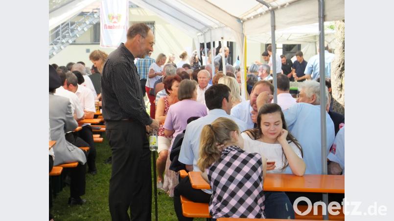 Pfarrer Gerhard Wagner begrüßt die Gäste und unterhält sich angeregt mit ihnen. ral