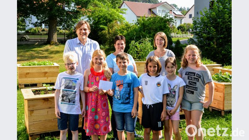 Stefan Reither, Gemeindereferentin Barbara Schlosser und Klassenleiterin Sabrina Reich (hinten, von links) zusammen mit den Ehenfelder Kommunionkindern bei der Spendenübergabe fdl