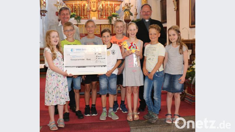Die Kastler Kommunionkinder übergeben mit Pfarrer Heribert Stretz (hinten rechts) eine Spende von 1000 Euro an Günther Lindner (hinten links) vom VKKK. rpp