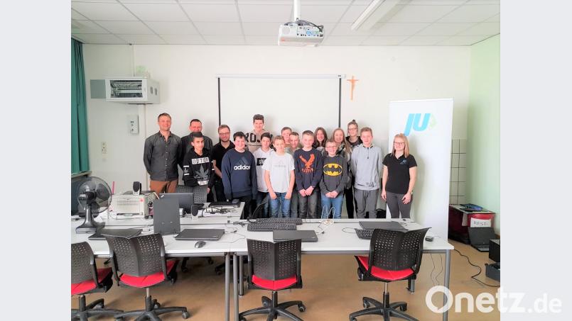 JU-Chef Christoph Müllhofer (links) und JU-Mitglied Andrea Herrmann (rechts) übergeben die Liste mit Lehrstellen an die Schüler der achten Klasse der Mittelschule. tu